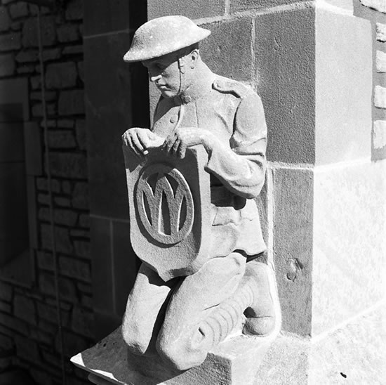 The Memorial Tower’s four corner spires are decorated with statues of kneeling World War I army soldiers and navy sailors. Depicted in service uniforms worn during active duty in battle, the enlisted men face down and hold shields in front of their chest. Their lack of emotion, distinguishing characteristics and insignia designating rank indicate they are archetypal soldiers representing all the MU men who died in the First World War. Protective figures, the soldiers and sailors continue to fight for liberty and freedom as they guard the university’s campus. Courtesy University Archives.