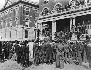 President Richard Jesse, unaware of the first Farmers’ Week, met agriculture students wearing work clothes in the hallway outside of MU’s chapel and would not permit them inside. The students gathered on the south steps of Jesse Hall, where Jesse (the bearded figure with his arm raised in the right center of the picture) chastised them for their disrespectful attire and ordered them to disband. They did and then paraded downtown with every available farm implement. Courtesy Mizzou Alumni Association.