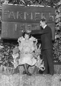 Dean Mumford crowns Farmers' Week Queen 1920 on a throne of corn. Courtesy University Archives.