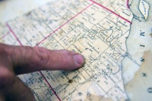 John Clay points to the current site of his family's farm from a book that dates back to the early 1900s called the "Standard Atlas of Moniteau County." 
