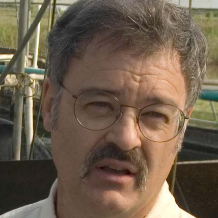 Portrait of David Brune with wire-rimmed glasses and dark mustache.