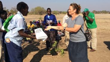 Kerry Clark, at right, at a village meeting in Mozambique where she taught people how to grow soybean.