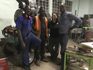 Clark and her team of Ghanaian trainers, from left to right, Hakeem Abdul-Karim, Imoro Donmuah and Jeffrey Appiagyei, pose in front of a thresher fabricated in Kigali, Rwanda. Photo courtesy Kerry Clark. 