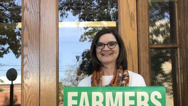 Kristi Livingston holds a Farmers for Bush sign. When working on George H.W. Bush's campaign, she came up with the design of the sign to show agriculture's support of Bush.