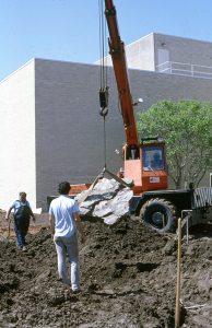 Physical Plant staff place a boulder as part of the dry creek construction.