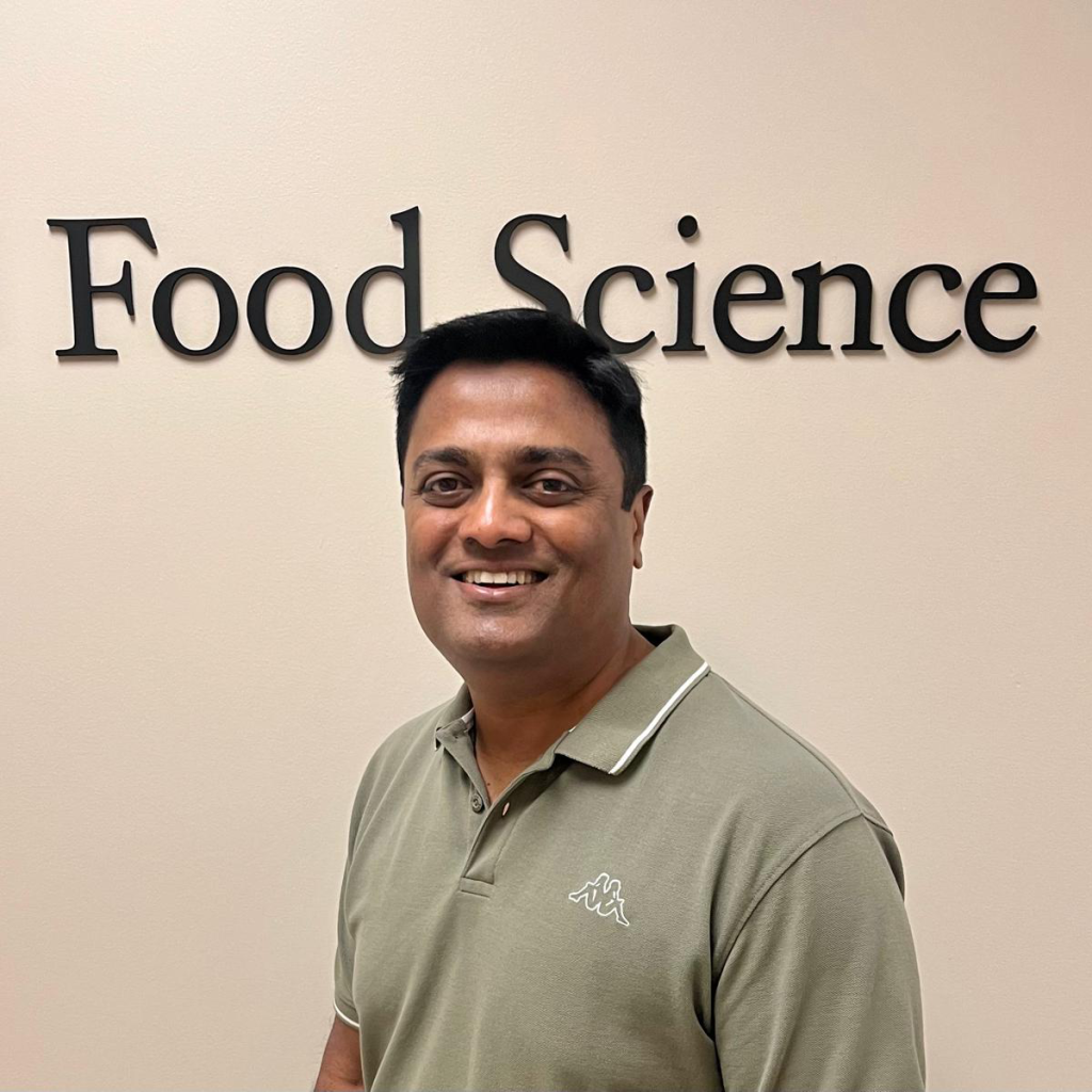 Kantha in front of Food Science sign.