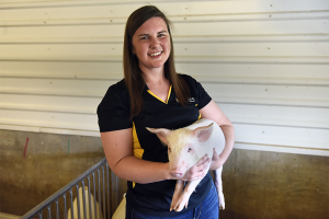 Corinne Bromfield holding a pig