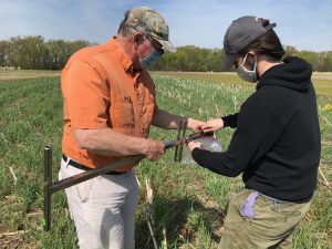 Kyle Paddock in the field with David Tague collecting soil samples