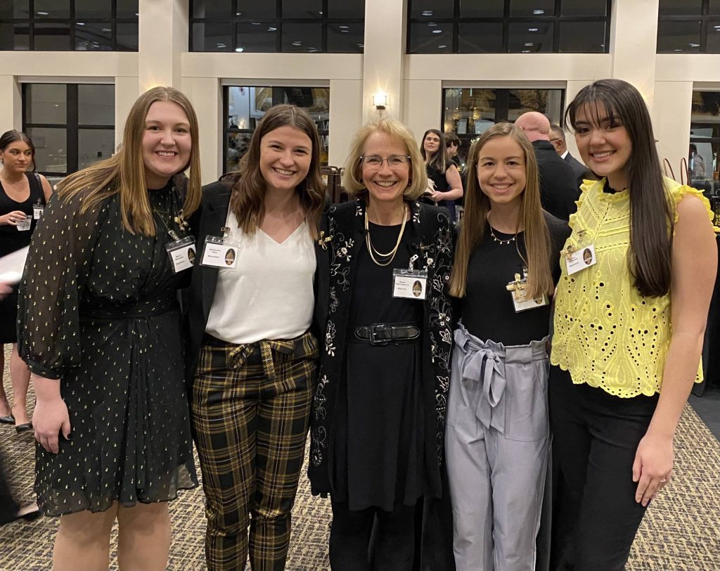 a group of 4 female students pose with Dr. Shari Freyermuth (center)