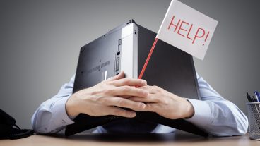 Worker with head down in laptop with a help sign