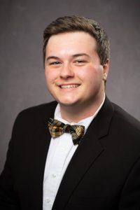 Photo of Grant Norfleet. Boy with brown hair, wearing a black blazer over a white shirt with a bow tie.