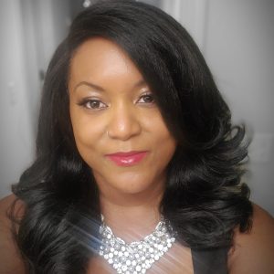 black woman with long curled hair, wearing a large sparkly statement necklace