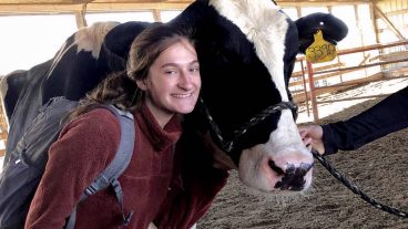 Emma Schudel poses with a dairy cow.