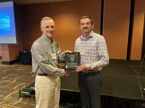 Caleb Grohmann receives an award from the National Swine Improvement Federation