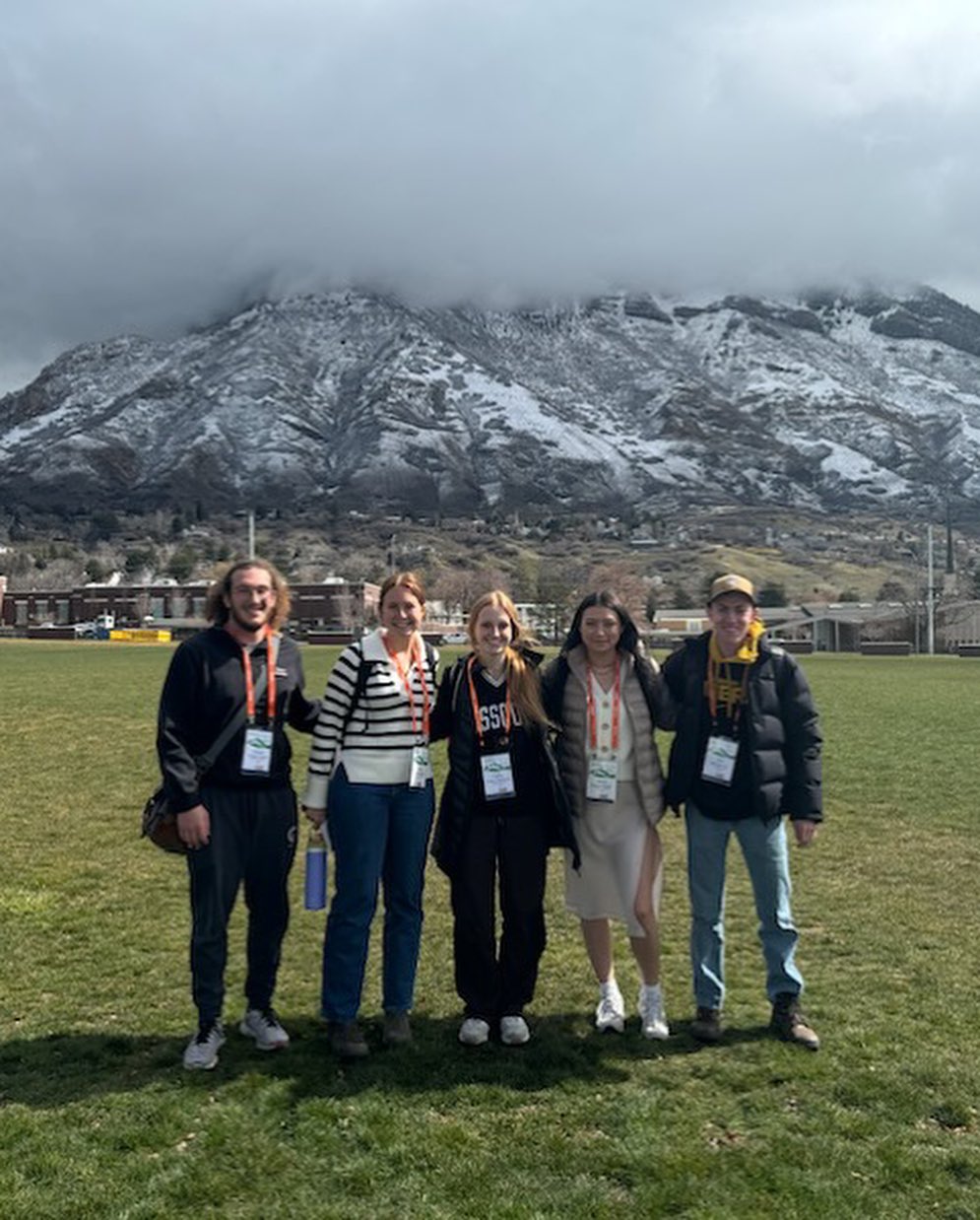 Five students pose in front of mountains.