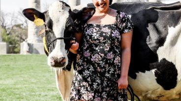 A student poses with a cow.