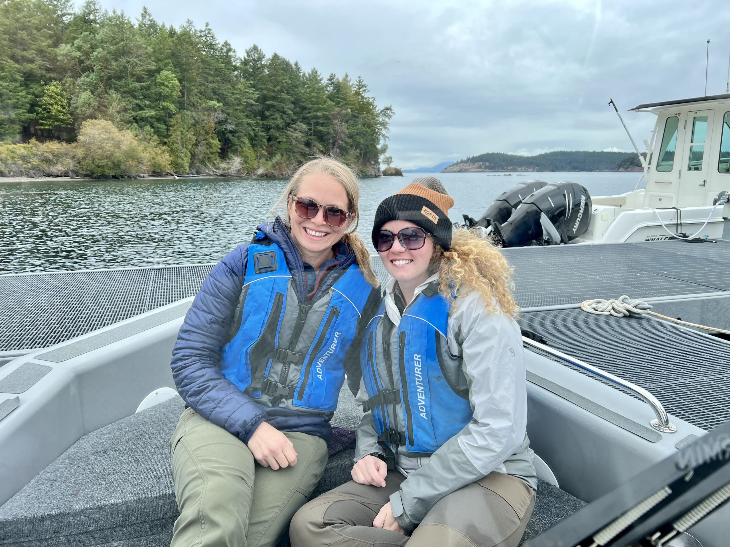 Two women pose on a small boat.