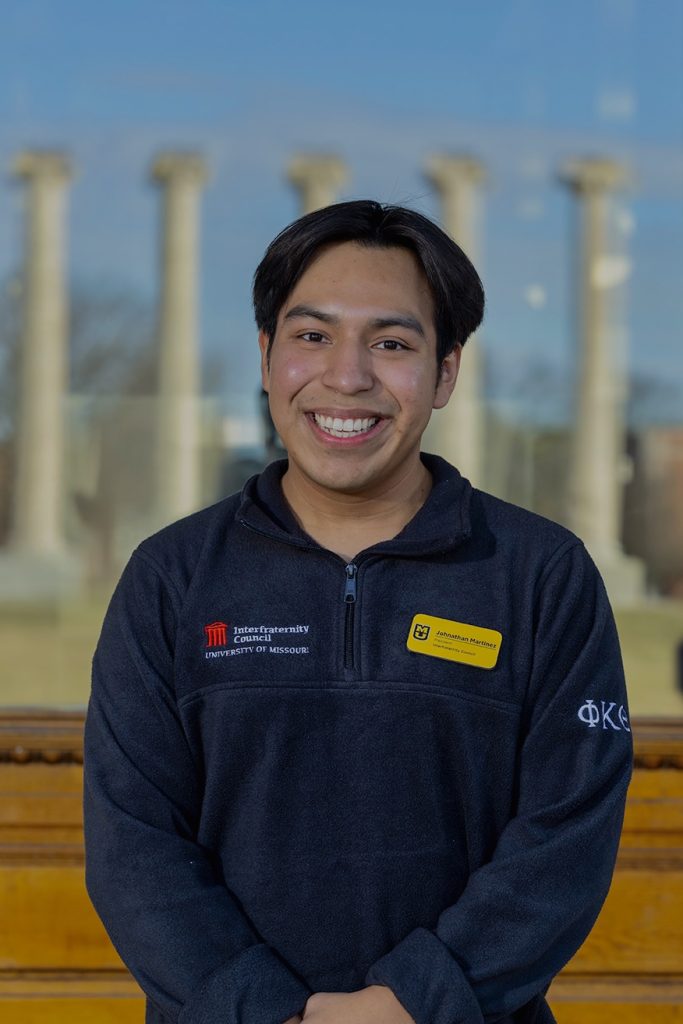 A student smiles for a portrait. 