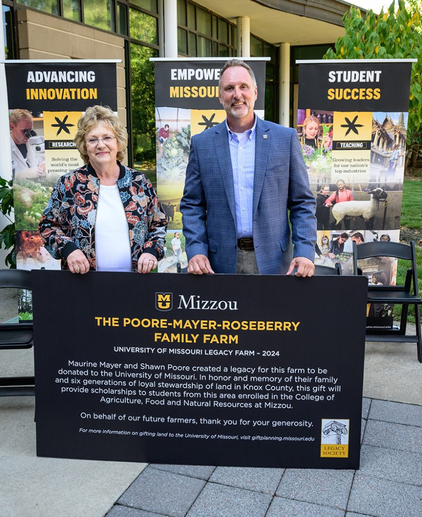 Maurine Mayer and Shawn Poore pose with the sign that will denote their family farm as a Mizzou Legacy Farm.