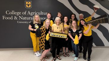 a group of people wearing black and gold