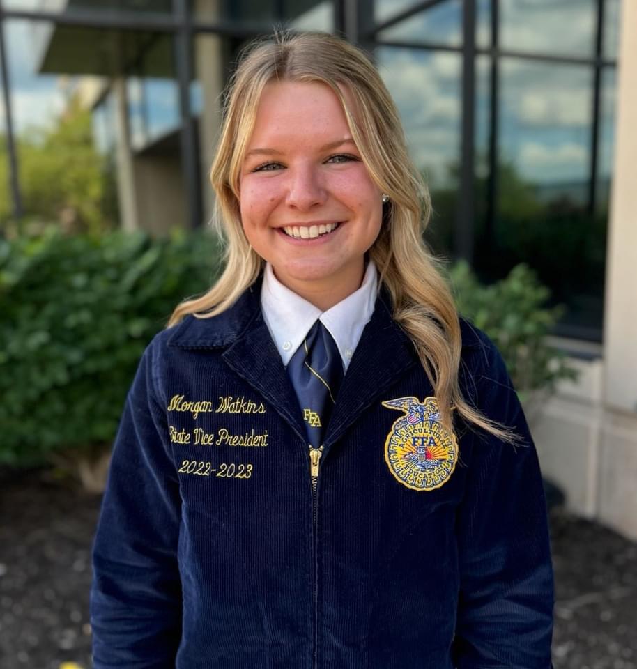 A student in an FFA jacket smiles for a portrait. 