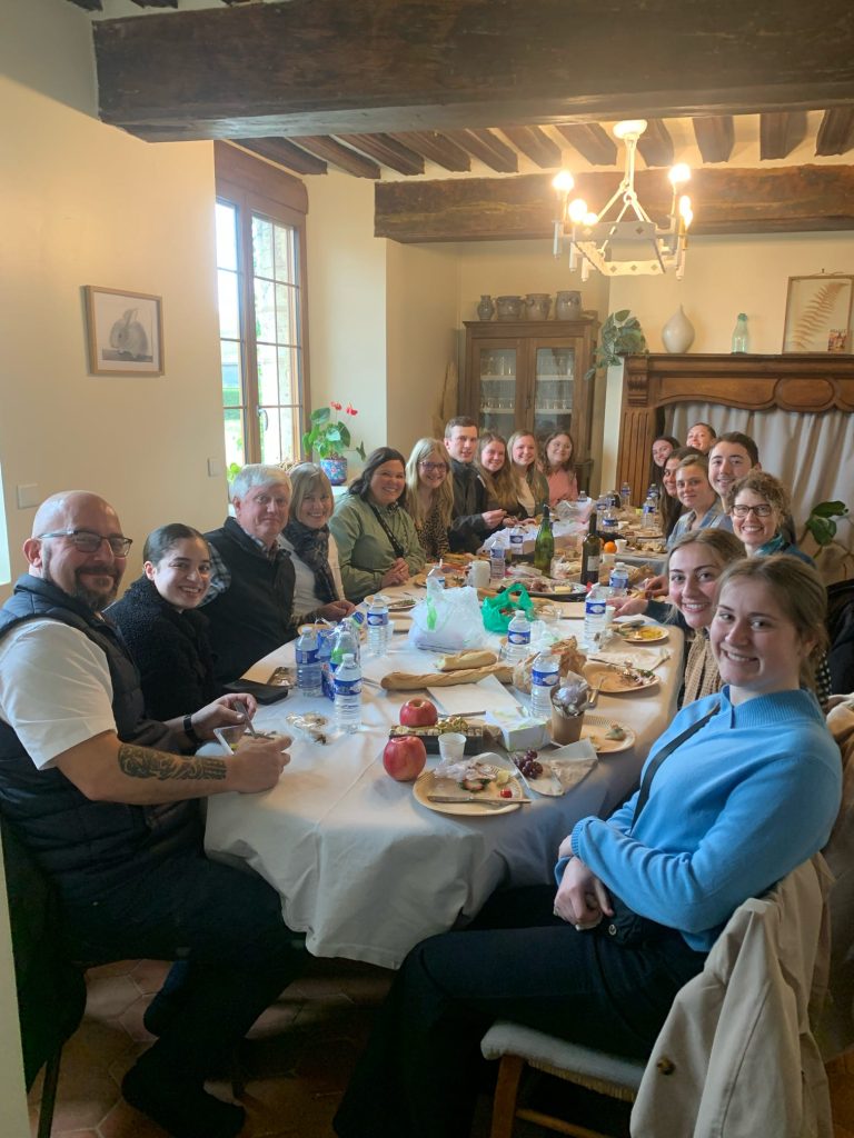 A photo of students seated around a large table for a meal. 