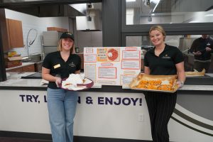 Two students pose with trays of food.