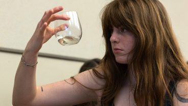 A student looks at a wine glass.