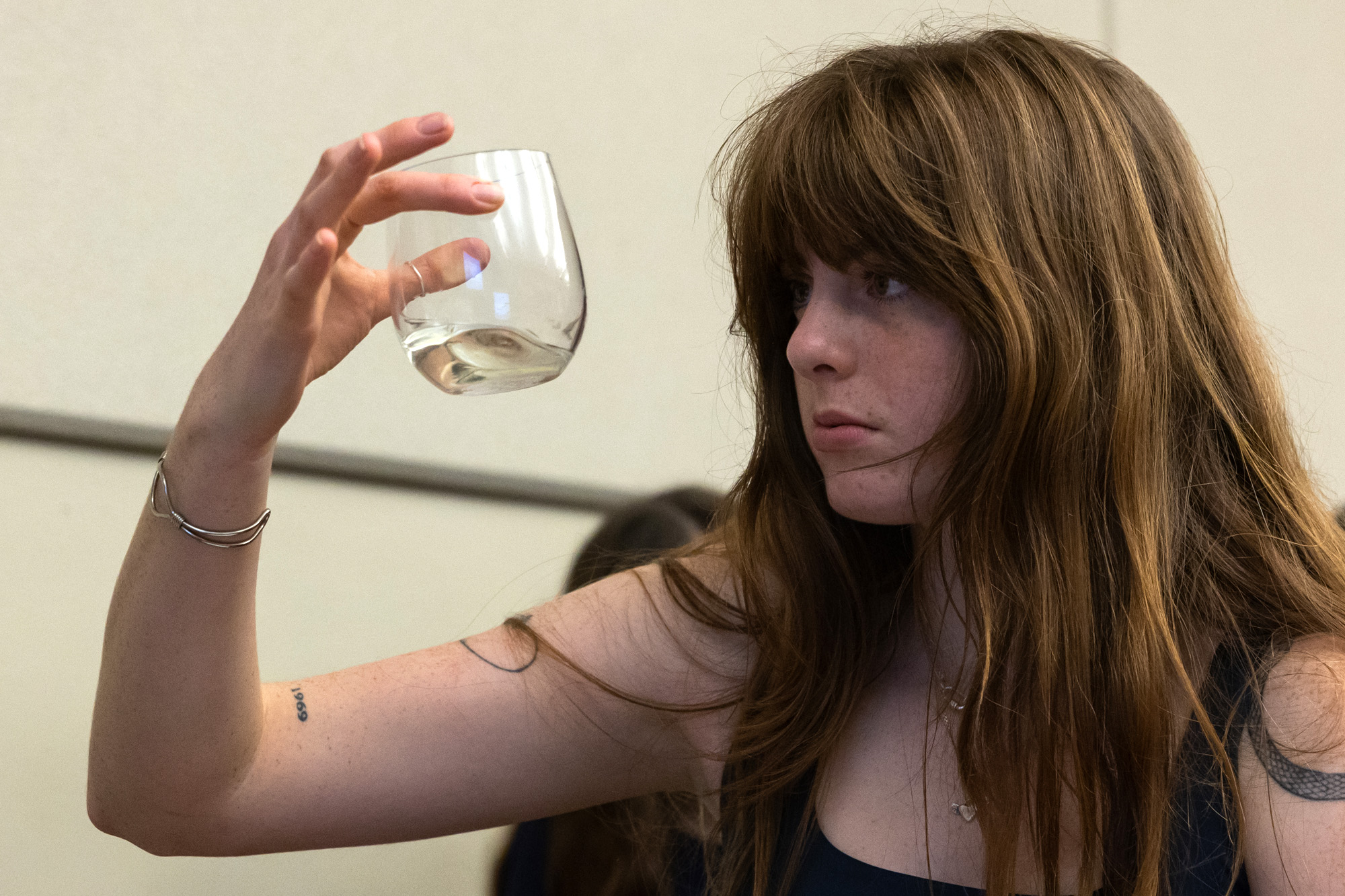 A student looks at a wine glass.