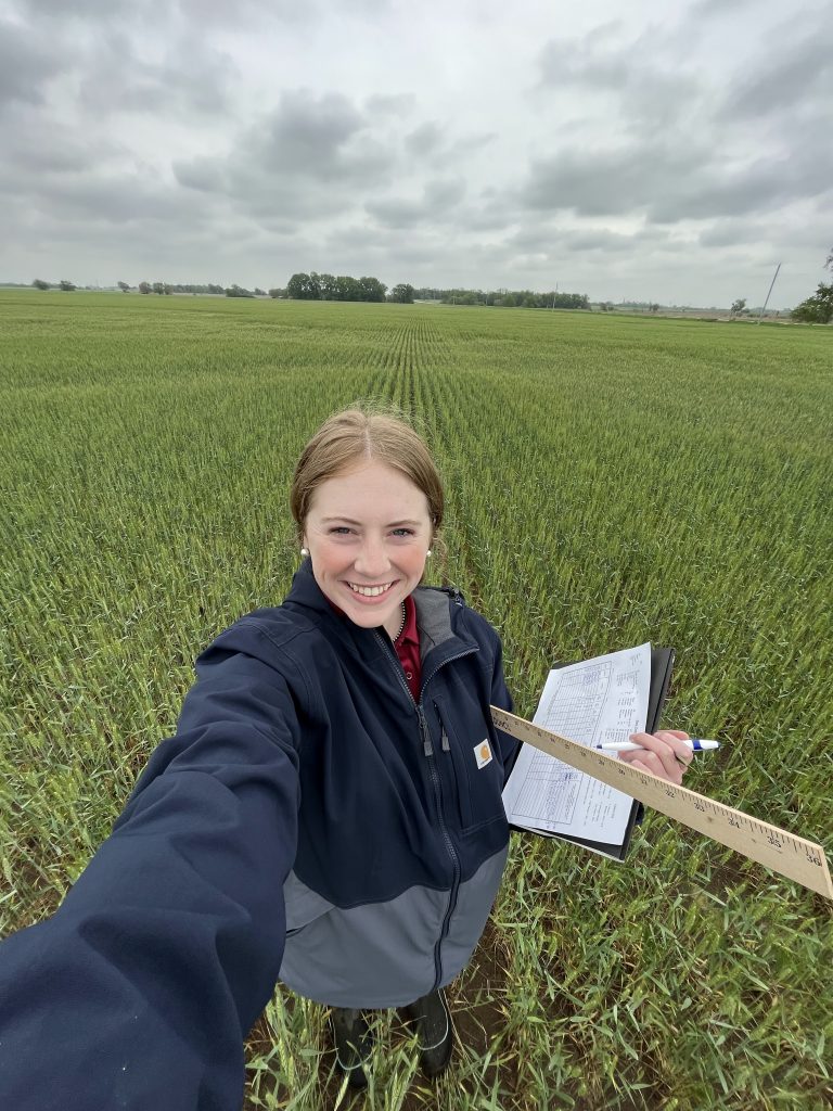 A woman takes a selfie in a field. 