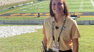 A student poses for a photo on the Mizzou football field.