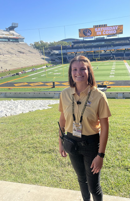 A student poses for a photo on the Mizzou football field. 