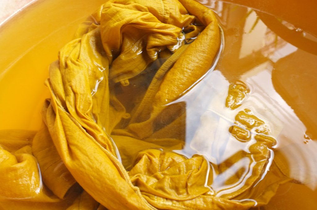 fabric in a yellow dye bath