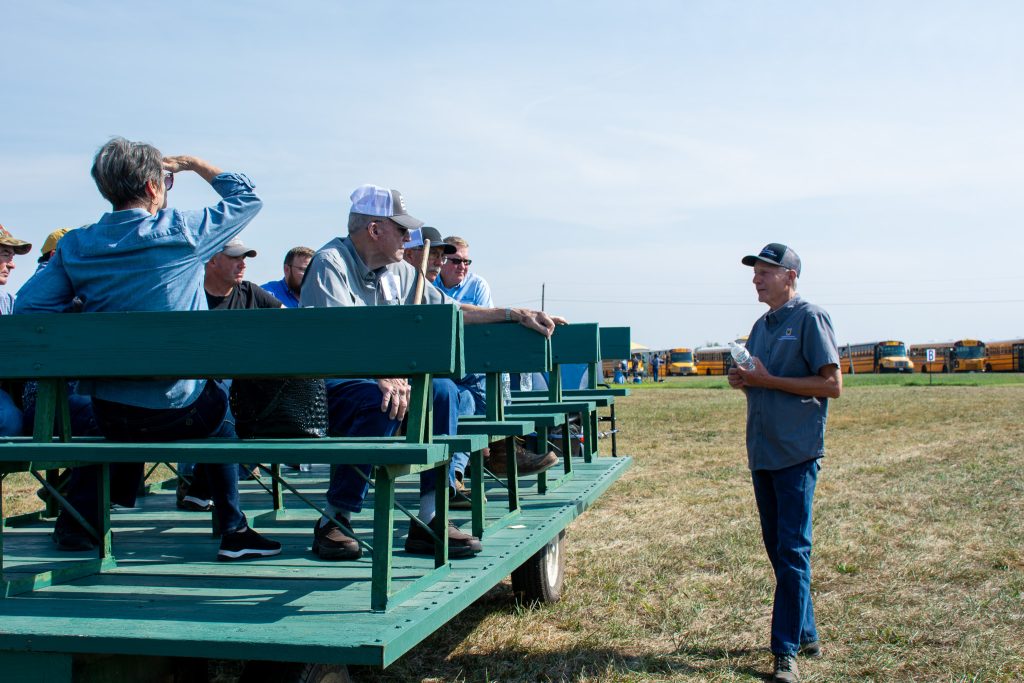 Andy Thomas speaks to a wagon of producers at Southwest REEC's Field Day 2025