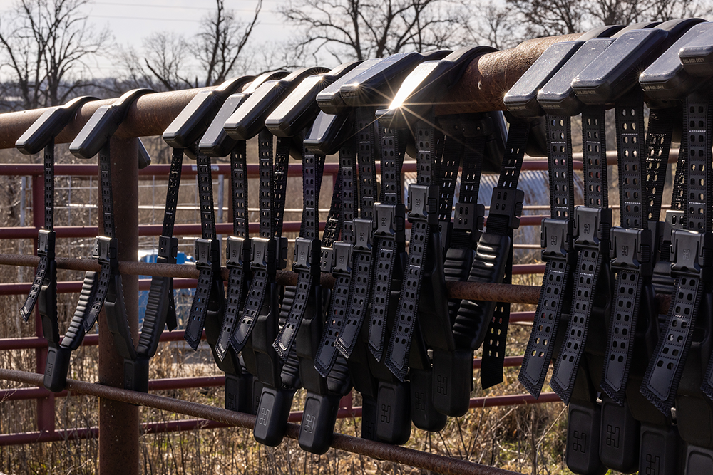 GPS collars hang on a fence.