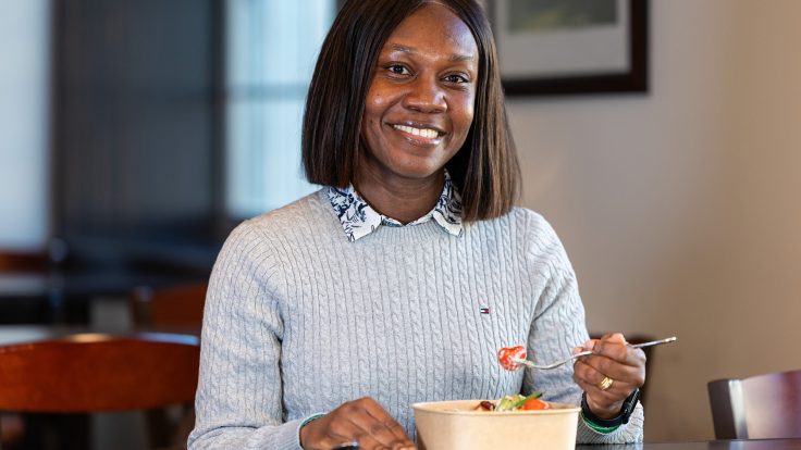 Smiling person eating lunch.