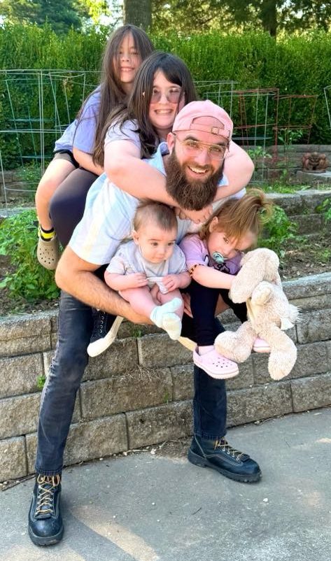 Ben Walters holding his four daughters.