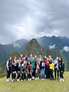 Ruterschmidt and members of Mizzou GMT pose for photo in front of mountain range.