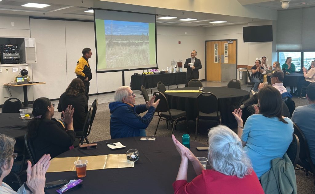 Attendees clap at a retirement party.