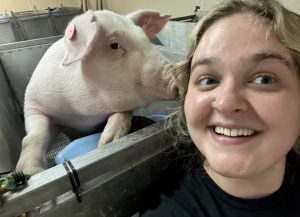 Abigail Dowell smiles with pig.