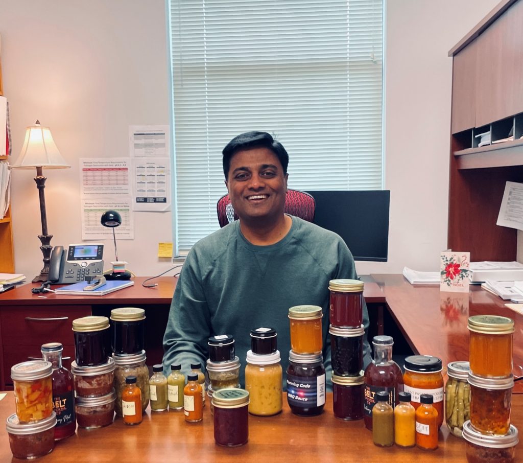 Kantha smiling in office with canned food.