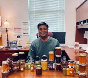 Kantha smiling in office with canned food.