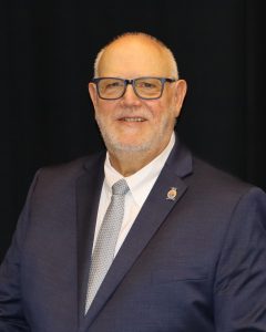 Keith Dietzschold, in blue suit and gray tie.