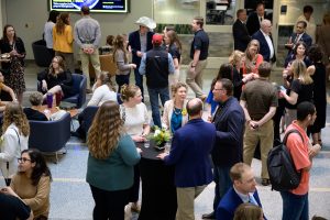 Attendees chat around tall tables at the reception before Celebration of Excellence 2026.