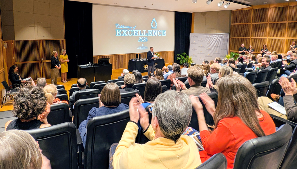 People clapping at award ceremony.