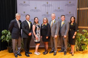 Award winners pose in front of a backdrop with the College of Agriculture, Food and Natural Resources logo on it.