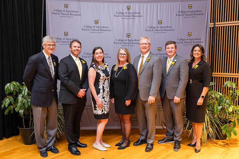 Award winners pose in front of a backdrop with the College of Agriculture, Food and Natural Resources logo on it. 