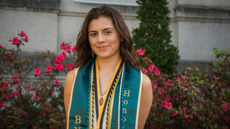 India Williams smiling wearing graduation stole and cords.