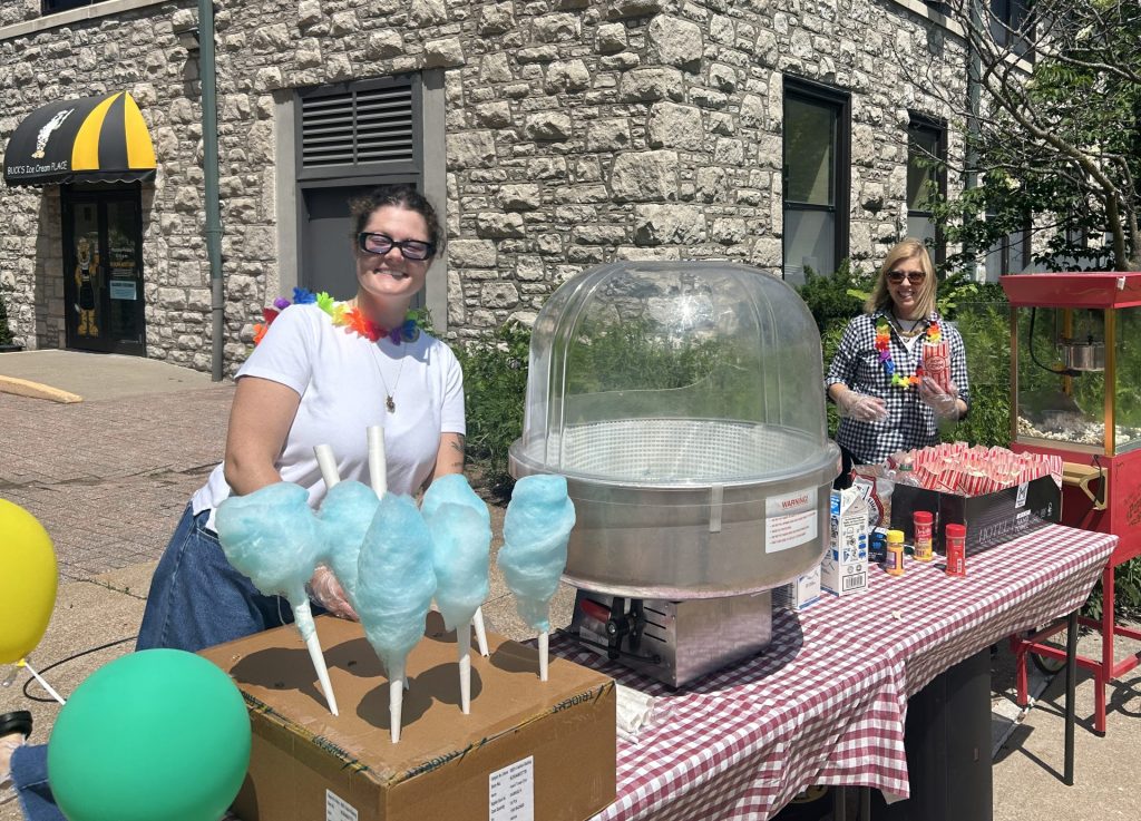 Volunteers make cotton candy and popcorn.
