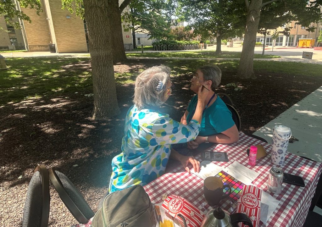Face painting a bee on an attendee.